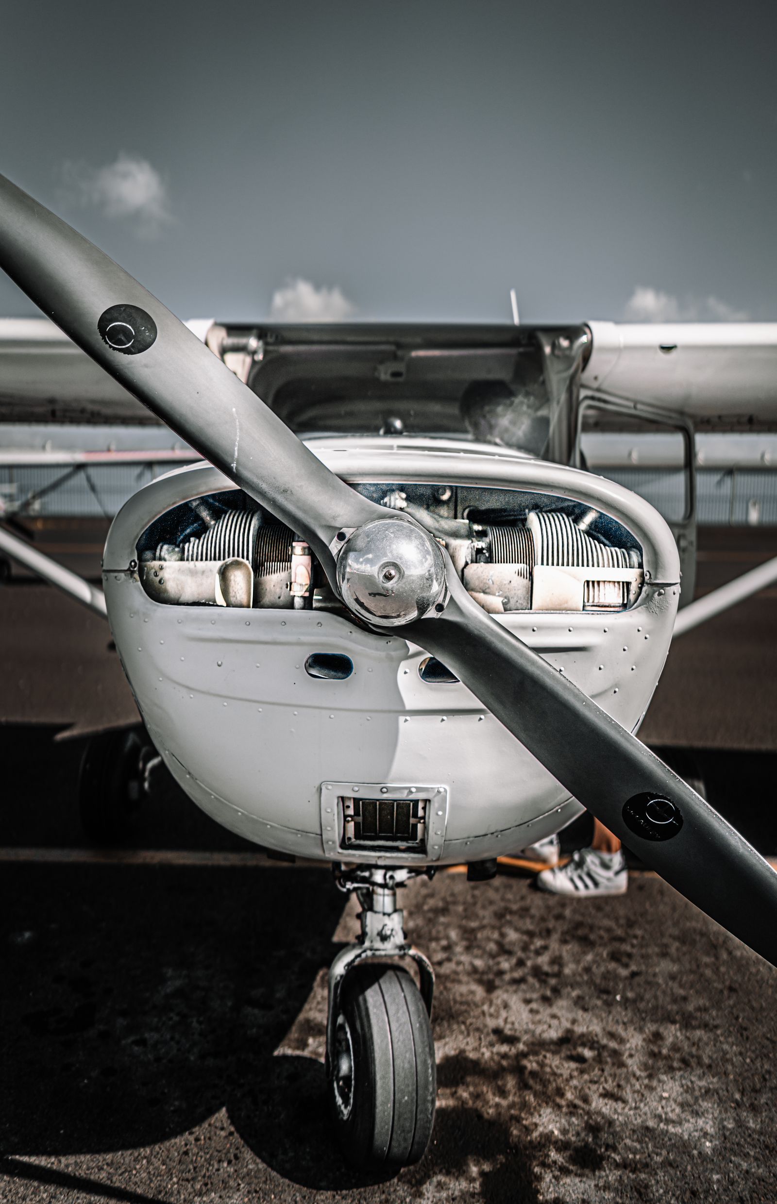 Tricycle-gear aeroplane parked on an airfield apron in bright daylight